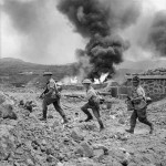 597px-Men_of_1st_Battalion_advance_past_a_burning_fuel_store_on_Pantelleria